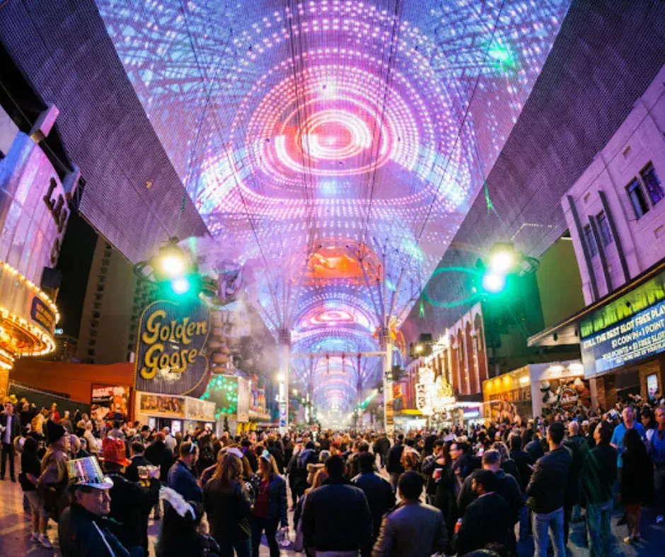 The illuminated canopy of Fremont Street Experience in Las Vegas, NV, glowing with vibrant colors against a lively night backdrop.