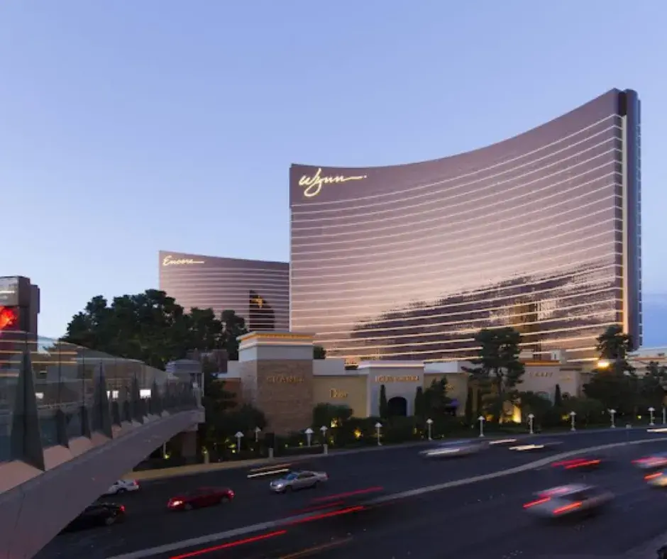 Wynn Las Vegas, NV, featuring its iconic architecture, lush gardens, and illuminated Lake of Dreams under the desert night sky.