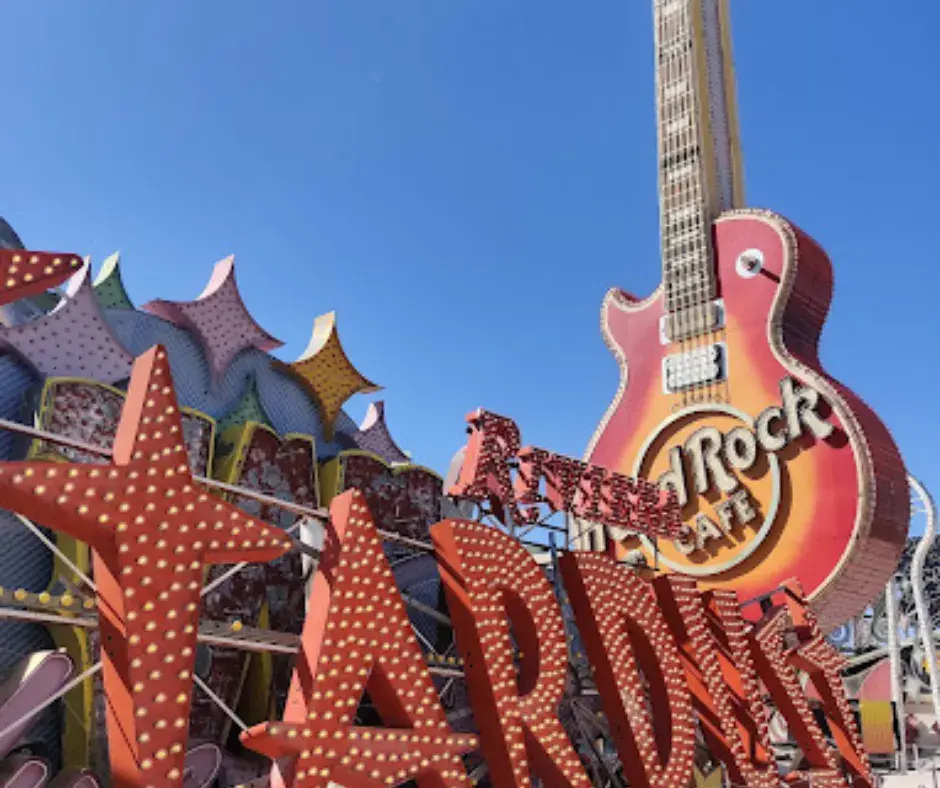An array of vintage neon signs glowing brightly at The Neon Museum in Las Vegas, NV, under the evening sky.